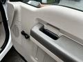 Interior door handle and control of a 2009 Ford F-550 with a textured panel and speaker grille visible
