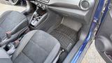 Interior of a 2019 Nissan Kicks featuring two front seats with textured fabric and a floor mat visible in the foreground