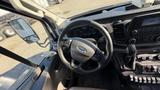 Interior view of a 2021 Ford Transit showing the steering wheel dashboard gear shifter and control panel