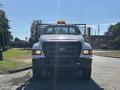 Front view of a 2004 Ford F-750 truck with a yellow light on the roof and a grille guard on the front