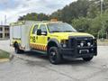 A yellow 2010 Ford F-550 Super Duty ambulance with emergency lights and medical response markings on the side