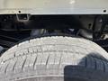 The image features the tire and undercarriage of a 2023 Ford F-350 SD showcasing the tread pattern and structural components of the vehicle