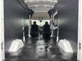 A 2020 Ford Transit 250 van interior with two front seats and an empty cargo space featuring a black floor and side walls