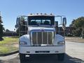 A white 2020 Peterbilt 330 truck viewed from the front with a chrome grille and several orange lights on top