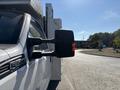 A 2011 Ford F-550 truck with a side mirror extended visible in the foreground