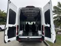 A 2020 Ford Transit 250 with open rear doors revealing a spacious interior with two seats and a clean cargo area