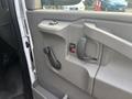 Interior door panel of a 2021 Chevrolet Express featuring a handle, door lock button, and window crank mechanism