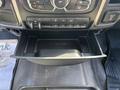 A lowered dashboard storage compartment in a 2014 RAM 5500 with various buttons and controls above it