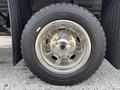Close-up of a shiny alloy wheel mounted on a 2016 RAM 5500 with a black tire featuring tread patterns visible on the surface
