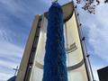 A vertical blue brush roller designed for car washing attached to a cylindrical structure