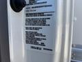 2022 Isuzu NRR truck with a vehicle emission control label attached to the door displaying details about compliance and specifications