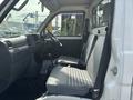 Interior view of a 2010 Daihatsu Hijet showcasing two front seats an instrument panel and a gear shift in the center console