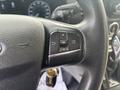 Close-up of the steering wheel controls of a 2021 Ford Transit-350 featuring buttons for navigation and settings