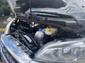 Close-up view of the engine compartment of a 2023 RAM Promaster 3500 featuring various components such as the coolant reservoir and engine parts