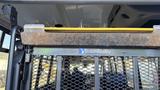 A 2021 Ford Transit interior featuring a BraunAbility logo on a metal barrier with a rusty top edge