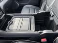 A detailed view of the center console of a 2021 RAM 1500 featuring a storage compartment with a sliding top and a textured surface