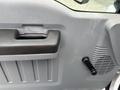 Close-up of the interior door handle and window crank of a 2018 Ford F-750 with a textured panel and air vent near the handle