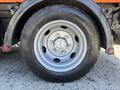 Close-up of a tire on a 2016 Isuzu NPR-HD featuring a silver rim with eight bolts and a Goodride tire on the side
