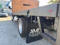 A 2014 RAM 5500 truck with a flatbed and mudflaps featuring a logo on the side