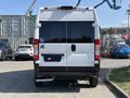 A 2022 RAM Promaster 350 viewed from the rear with a wheelchair accessibility symbol on the back door and a black bumper