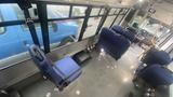 Interior view of a 2021 Ford Transit van featuring blue upholstered seats and a spacious floor area with visible mounting points for additional seating