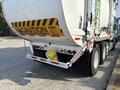 A 2011 Autocar Xpeditor garbage truck with a yellow container secured on the back and caution signage displayed on the side