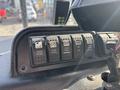 The dashboard of a 2011 Autocar Xpeditor featuring various control buttons including cruise control settings engine brake and headlight controls