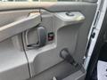 Interior door panel of a 2021 Chevrolet Express featuring a door handle a window control button and a manual door lock mechanism