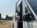 A 2018 Ford Econoline with a visible side mirror and door, featuring a white exterior and a tall, boxy design
