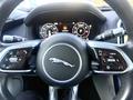 Steering wheel of a 2020 Jaguar XE featuring a Jaguar logo and various control buttons for functions like cruise control and audio settings
