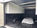 A 2020 Ford F-150 with an open truck bed featuring a large metallic storage box and a silver truck part lying inside