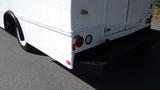 A white 2004 Freightliner MT45 with a boxy shape and large rear bumper showcasing round tail lights and side-facing indicator lights