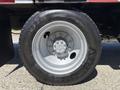 Close-up of a tire and wheel on a 2011 International 4300 with a silver rim and black tread showing the brand name Artisun